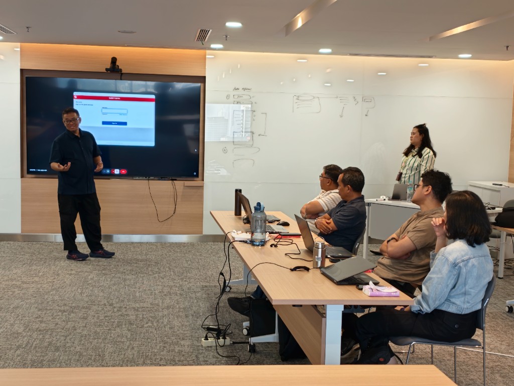 Participants at the table during a Hyperjump AI workshop, laptops open