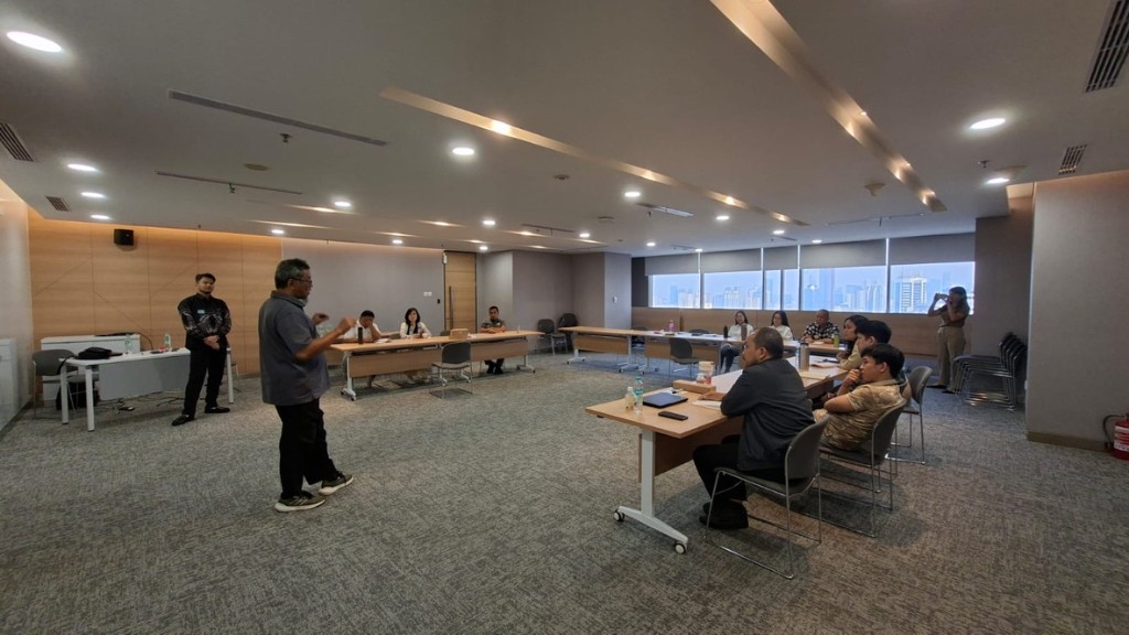 Wide view of a Hyperjump AI workshop with the team seated around a U-shaped table